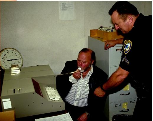 A Santa Monica police officer administers a breathalyzer test to a man to determine the alcohol level in his bloodstream.